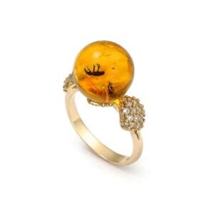 Gold ring with a unique amber ball with an inclusion and zircons